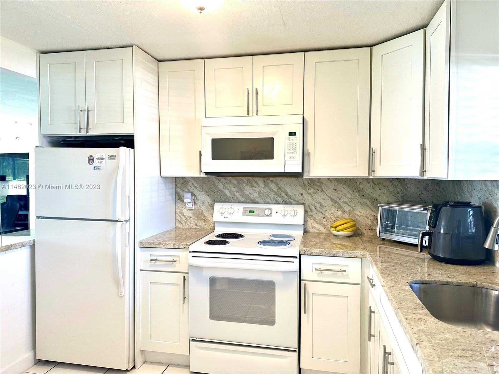 2580 West 67th Place, Unit 1011 Hialeah, FL 33016 - Photo 5 of 23 a kitchen with a refrigerator and a sink