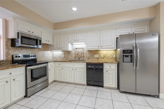 a kitchen with stainless steel appliances granite countertop a refrigerator sink and stove