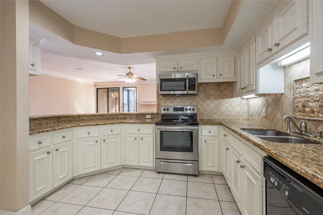 a kitchen with granite countertop a sink stove and cabinets