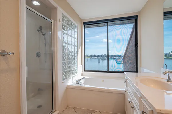 a bathroom with a tub sink and mirror