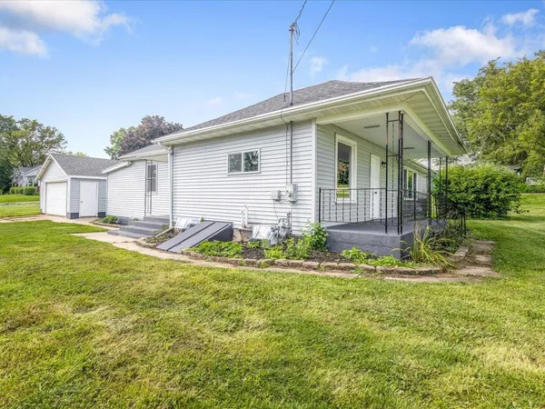 a kitchen with stainless steel appliances granite countertop a refrigerator a sink dishwasher a stove and white countertops with wooden floor