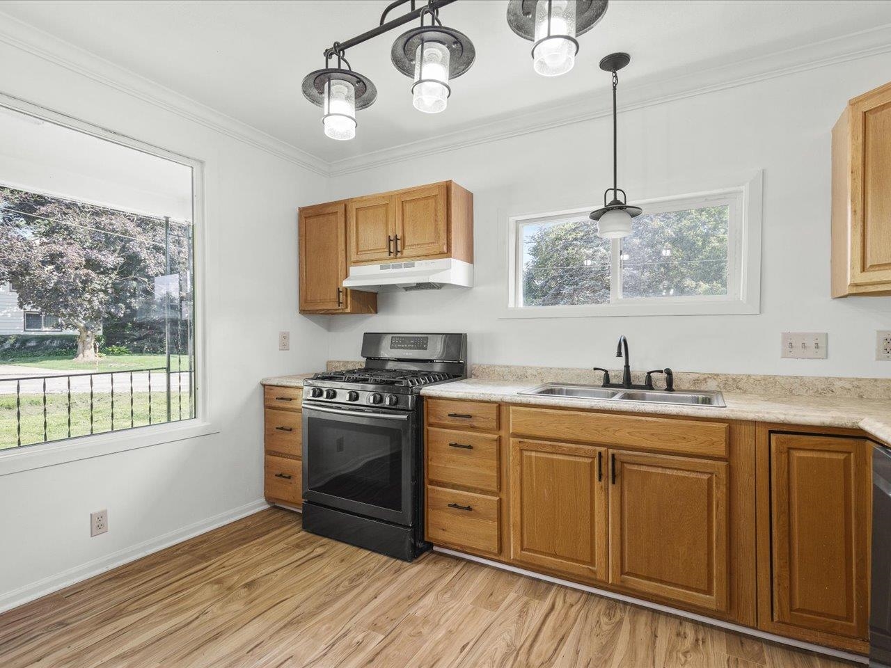 140 East Walnut Street Cedarville, IL 61032 - Photo 21 of 37 a kitchen with stainless steel appliances granite countertop a stove a sink dishwasher and white cabinets with wooden floor