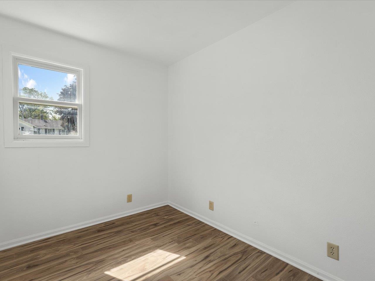 140 East Walnut Street Cedarville, IL 61032 - Photo 31 of 37 a view of an empty room with wooden floor and a window