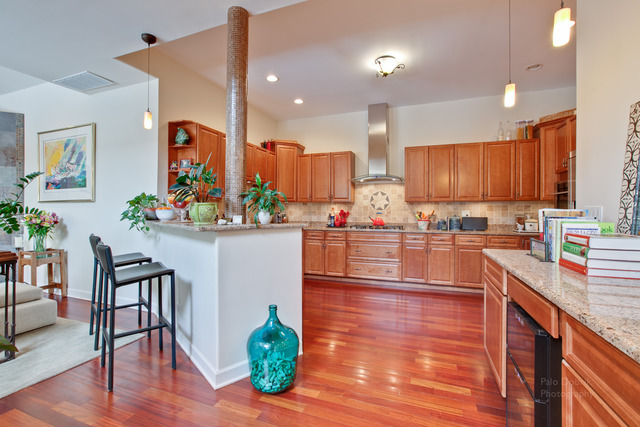 690 Lyster Road Highwood, IL 60040 - Photo 7 of 25 a kitchen with stainless steel appliances wooden floor dining table chairs and wooden cabinets