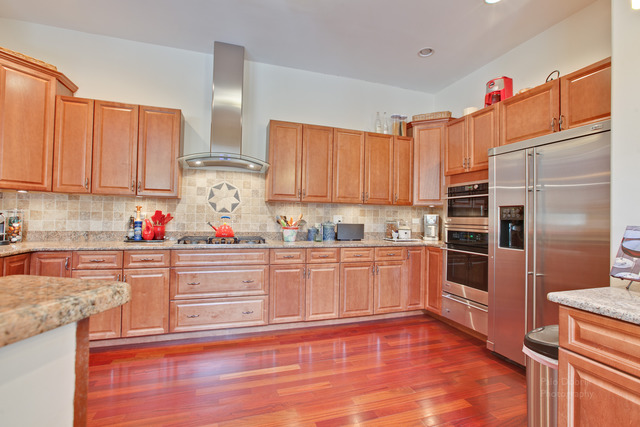 690 Lyster Road Highwood, IL 60040 - Photo 9 of 25 a kitchen with granite countertop a refrigerator and wooden cabinets