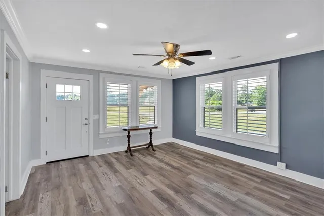 a view of an empty room with a window and a dresser