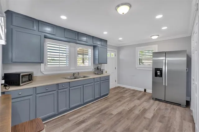 a large kitchen with stainless steel appliances granite countertop a refrigerator and a sink