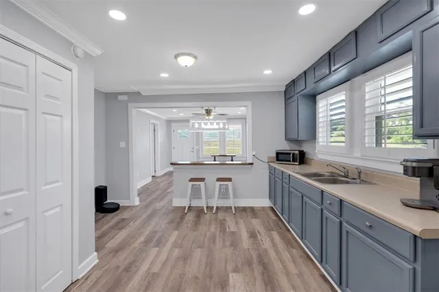 a large kitchen with a lot of counter space and a wooden floor