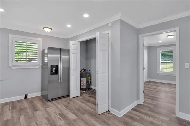 an empty room with wooden floor closet and windows