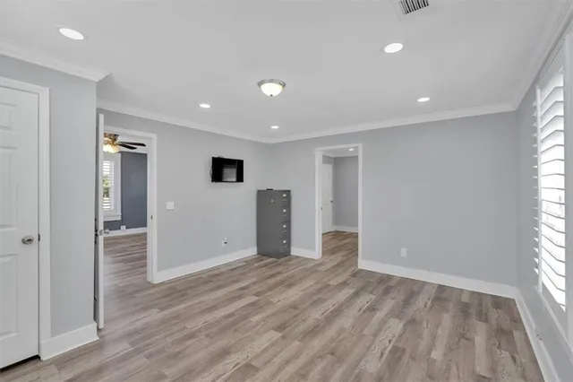 a view of empty room with wooden floor and window