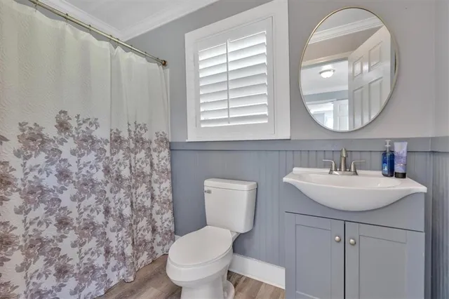 a bathroom with a toilet sink and mirror