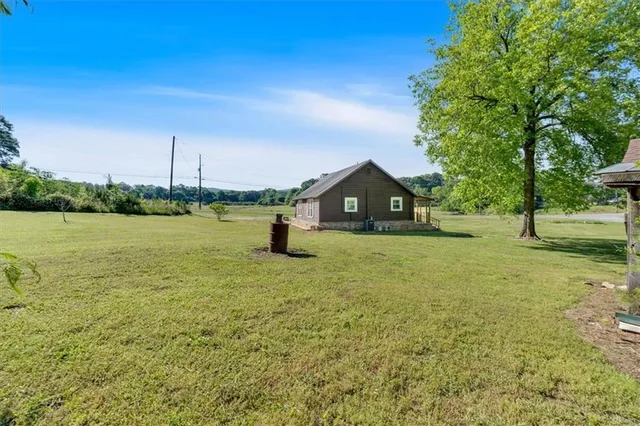 a front view of a house with a yard and lake view