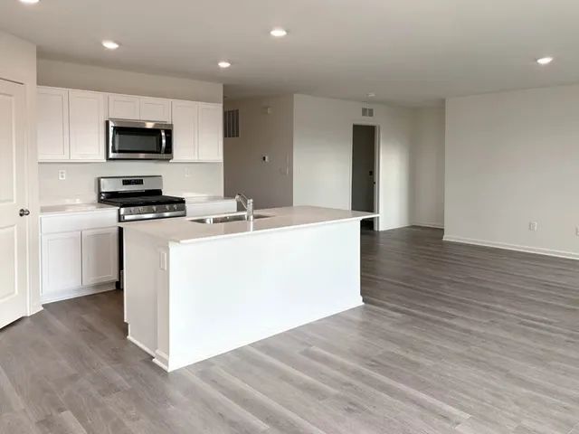a kitchen with a sink a microwave and cabinets