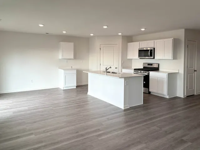 a kitchen with stainless steel appliances granite countertop a stove top oven a sink and a microwave