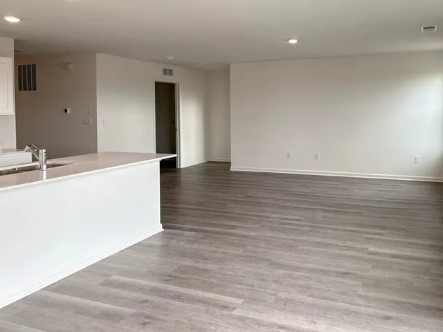 a view of a kitchen with wooden floor and a sink