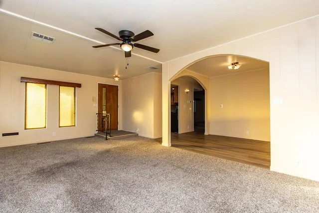a view of a livingroom with a ceiling fan and window