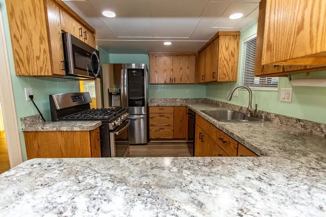 a kitchen with stainless steel appliances granite countertop a sink stove and granite counter top