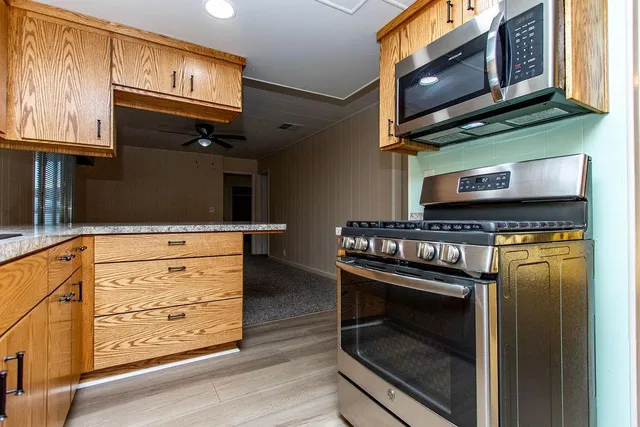 a kitchen with stainless steel appliances granite countertop a stove microwave and cabinets