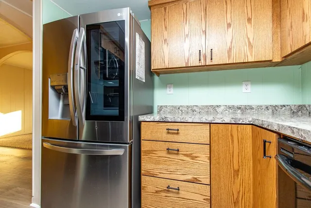 view of kitchen with granite countertop cabinets and refrigerator