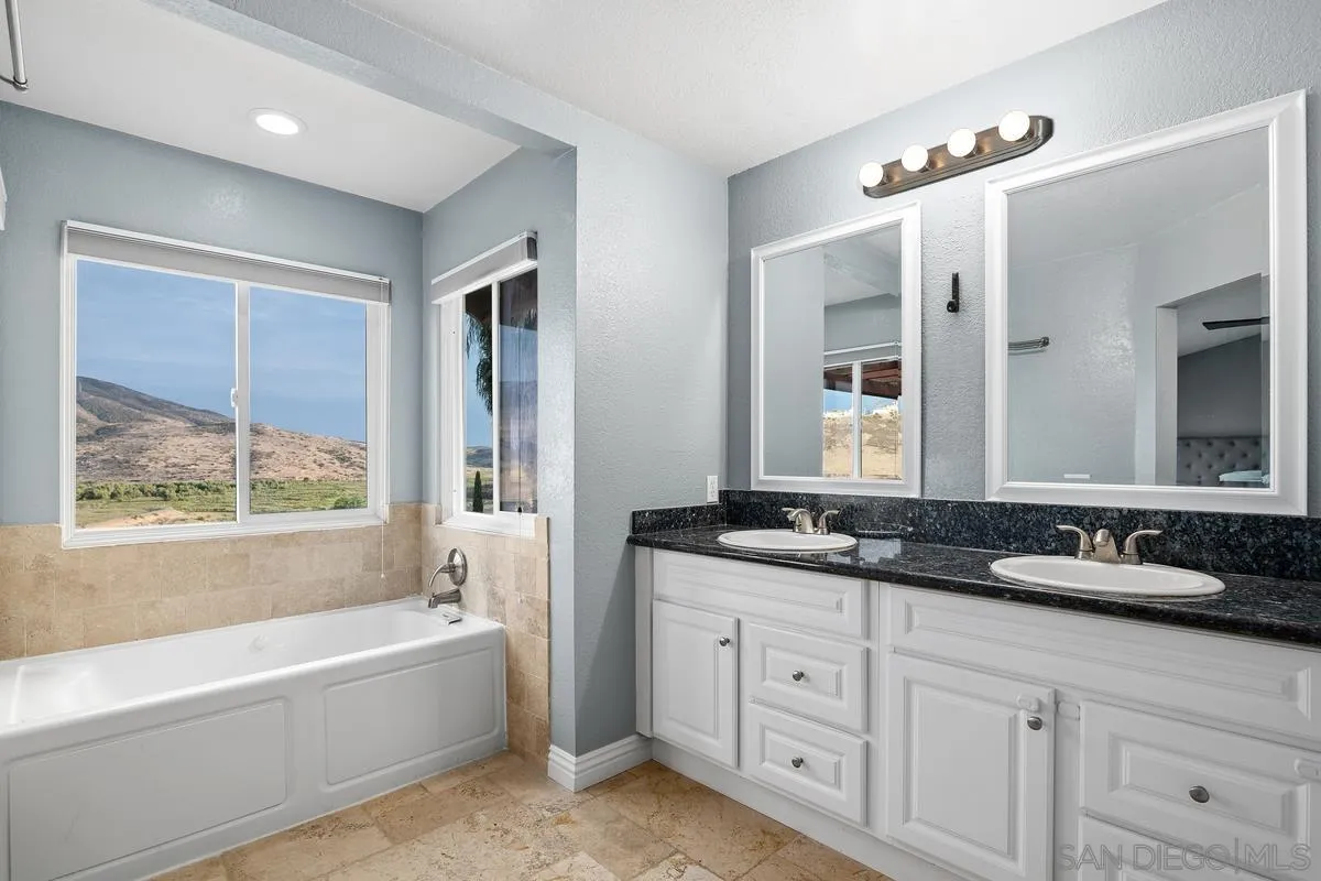 10145 Greenleaf Road Spring Valley, CA 91977 - Photo 18 of 37 a bathroom with a granite countertop tub sink double vanity and mirror
