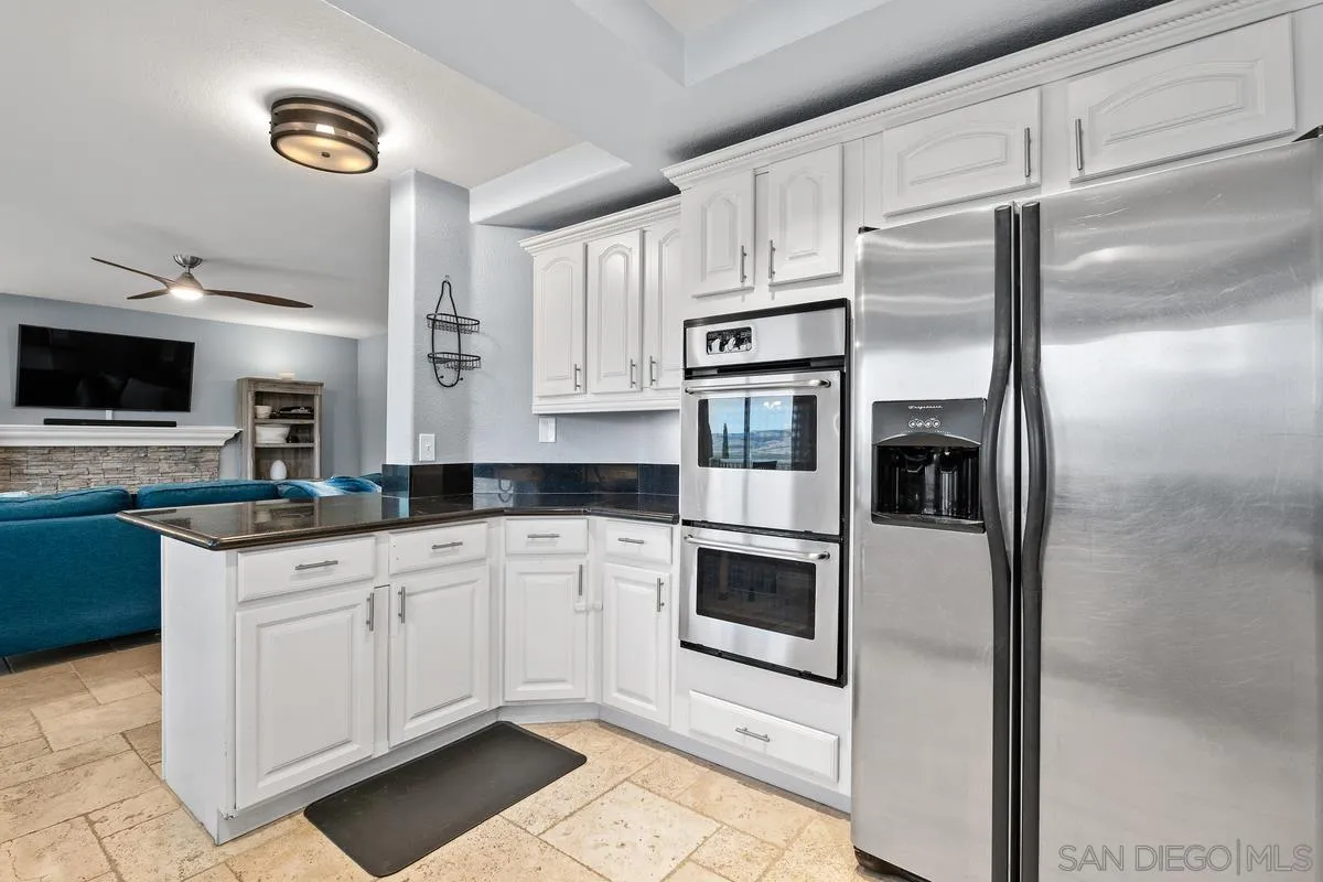 10145 Greenleaf Road Spring Valley, CA 91977 - Photo 22 of 37 a kitchen with stainless steel appliances and white cabinets