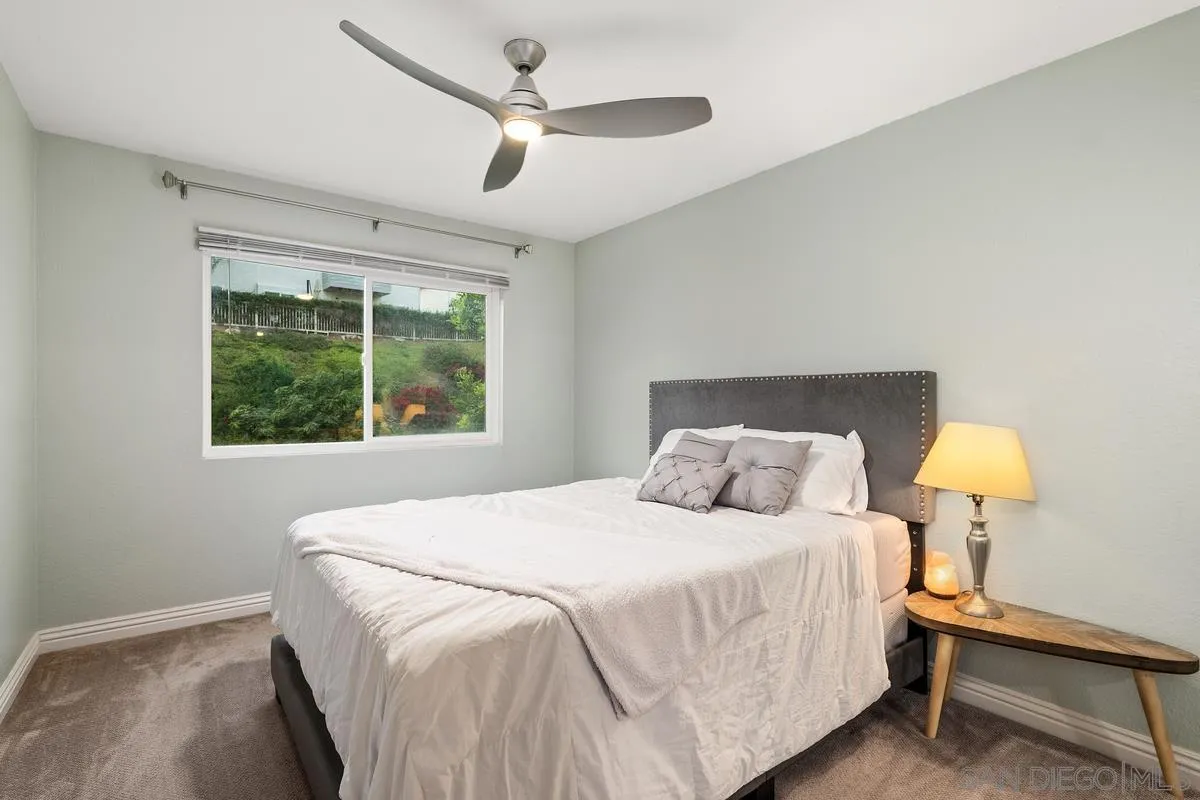 10145 Greenleaf Road Spring Valley, CA 91977 - Photo 27 of 37 a bedroom with a bed and a lamp on table