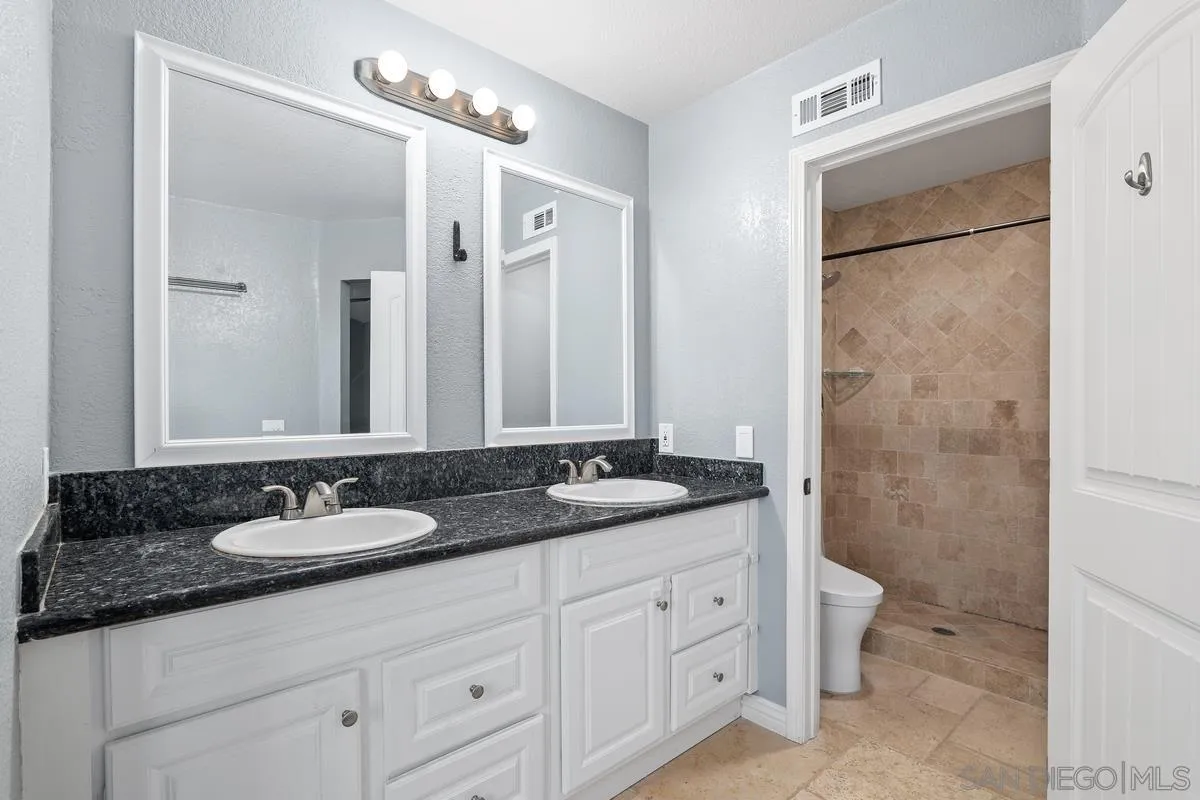 10145 Greenleaf Road Spring Valley, CA 91977 - Photo 29 of 37 a bathroom with a granite countertop sink and a mirror