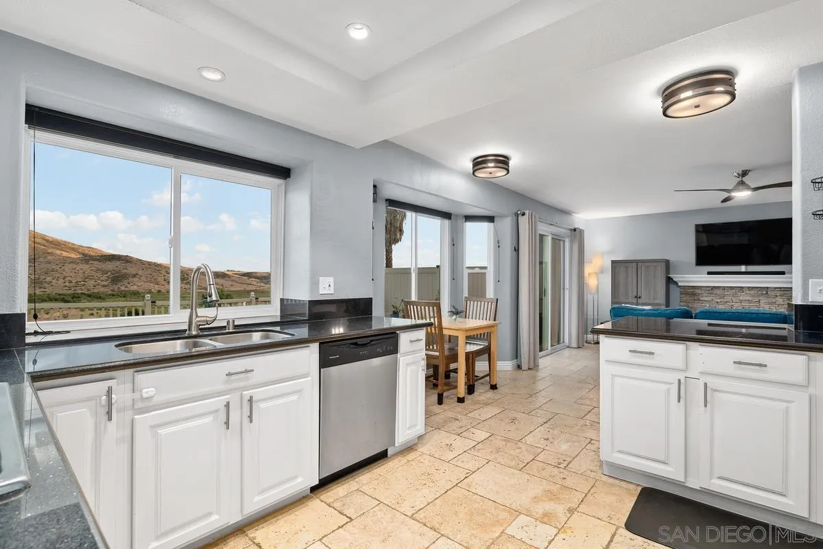 10145 Greenleaf Road Spring Valley, CA 91977 - Photo 8 of 37 a large kitchen with kitchen island granite countertop a stove a sink a dining table and chairs