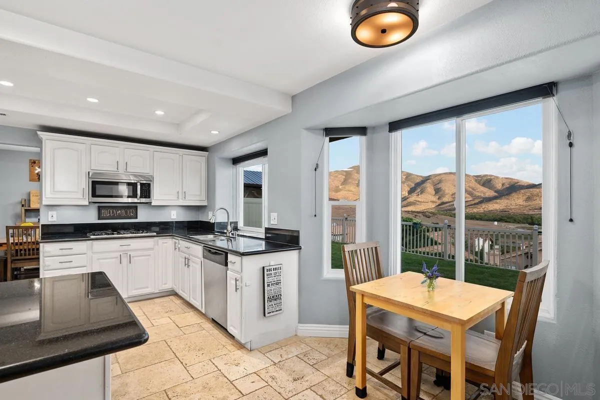 10145 Greenleaf Road Spring Valley, CA 91977 - Photo 10 of 37 a kitchen with stainless steel appliances granite countertop a stove a sink a microwave and a refrigerator