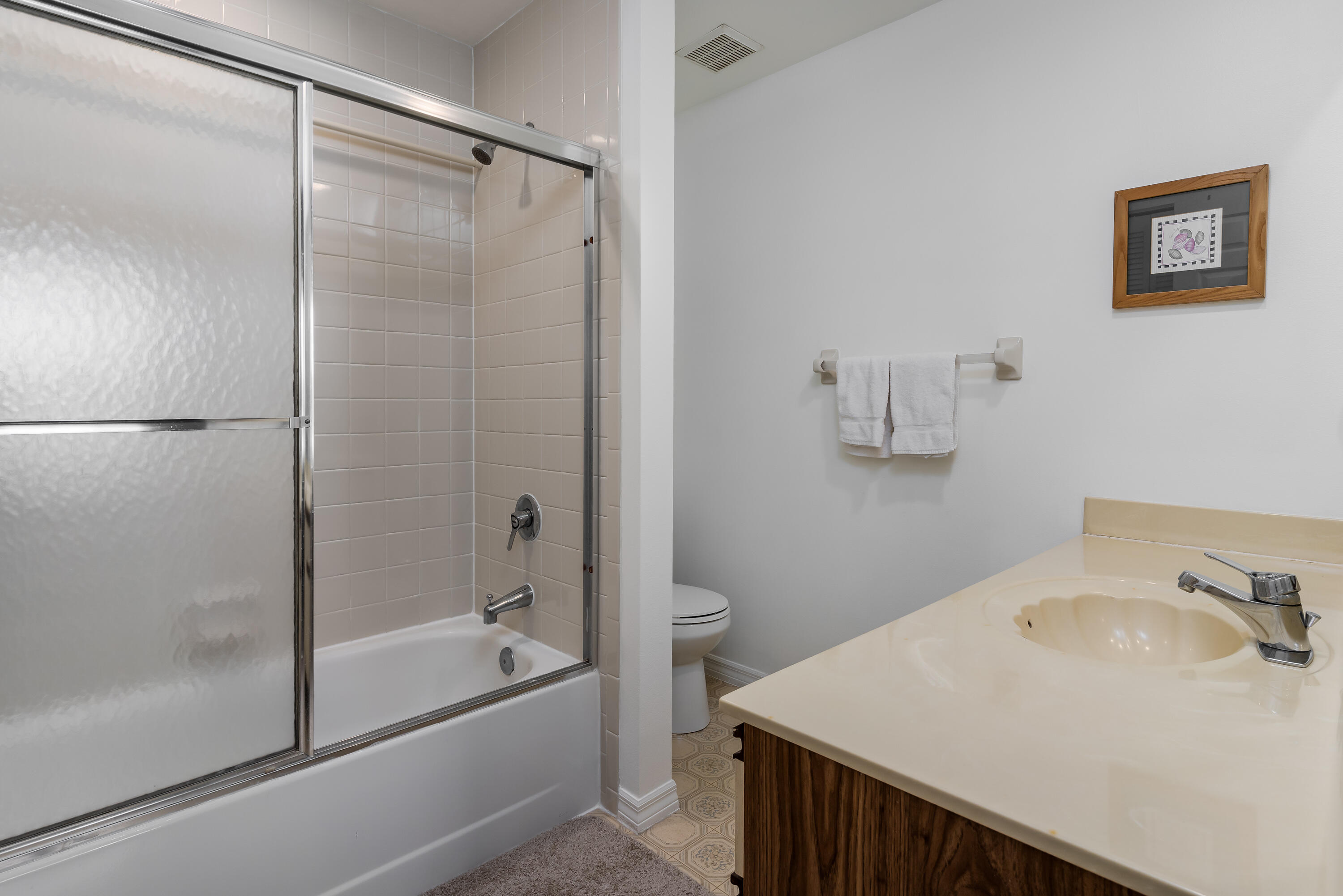 809 Augusta Boulevard, Unit 6 Naples, FL 34113 - Photo 13 of 24 a bathroom with a granite countertop sink toilet and shower
