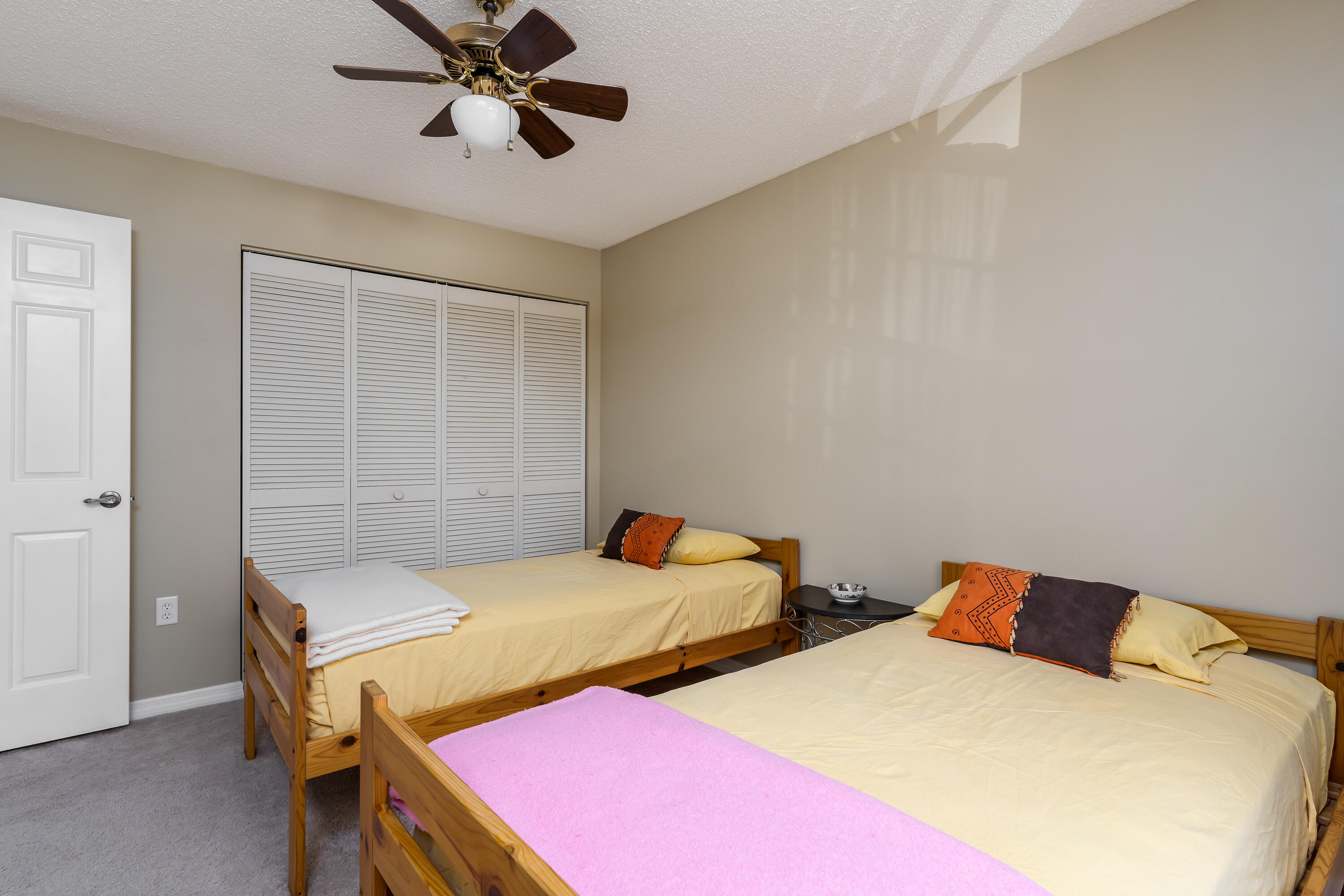 809 Augusta Boulevard, Unit 6 Naples, FL 34113 - Photo 15 of 24 a bedroom with two beds and a ceiling fan
