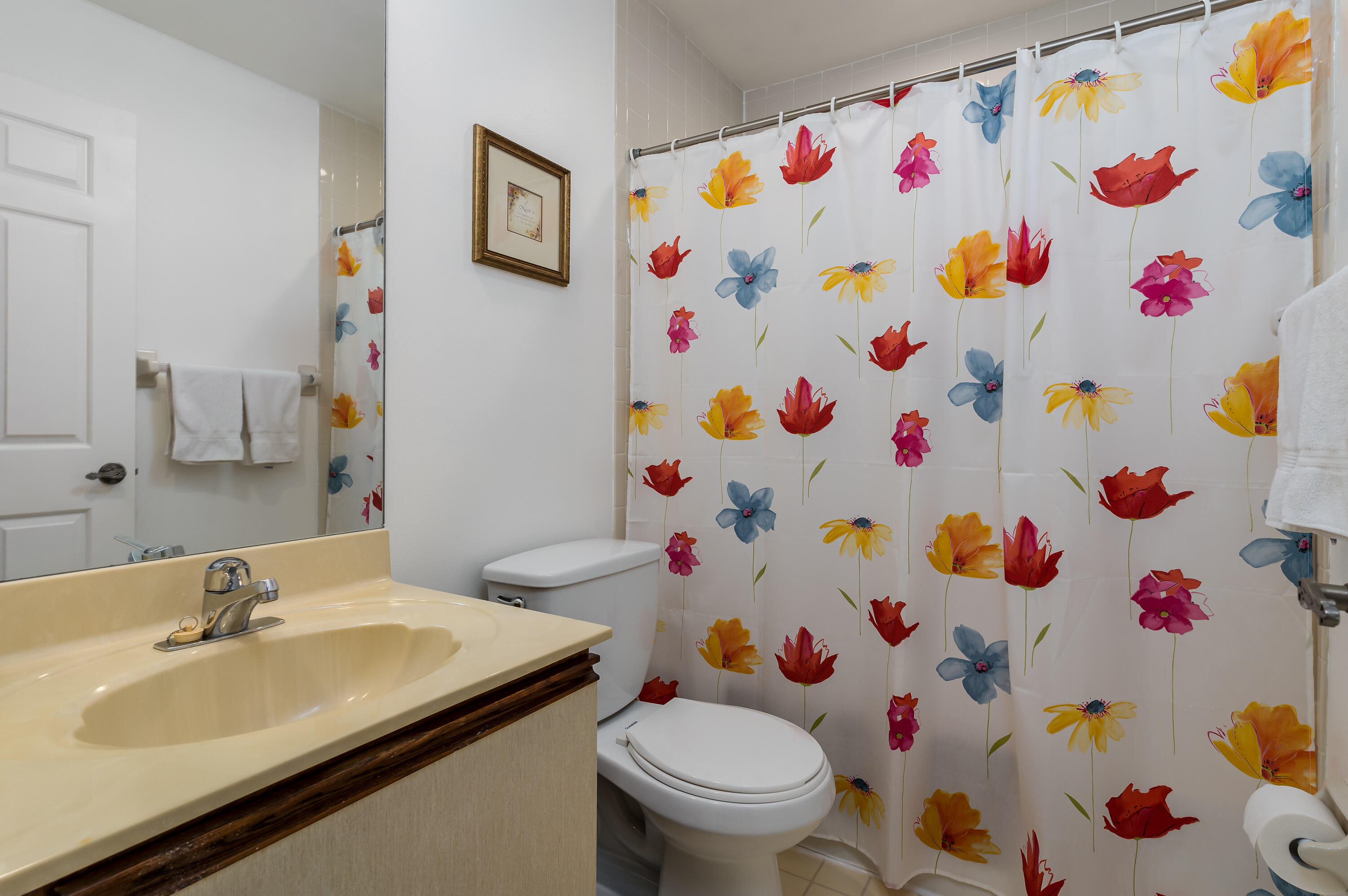809 Augusta Boulevard, Unit 6 Naples, FL 34113 - Photo 16 of 24 a bathroom with a sink a toilet and a shower curtain