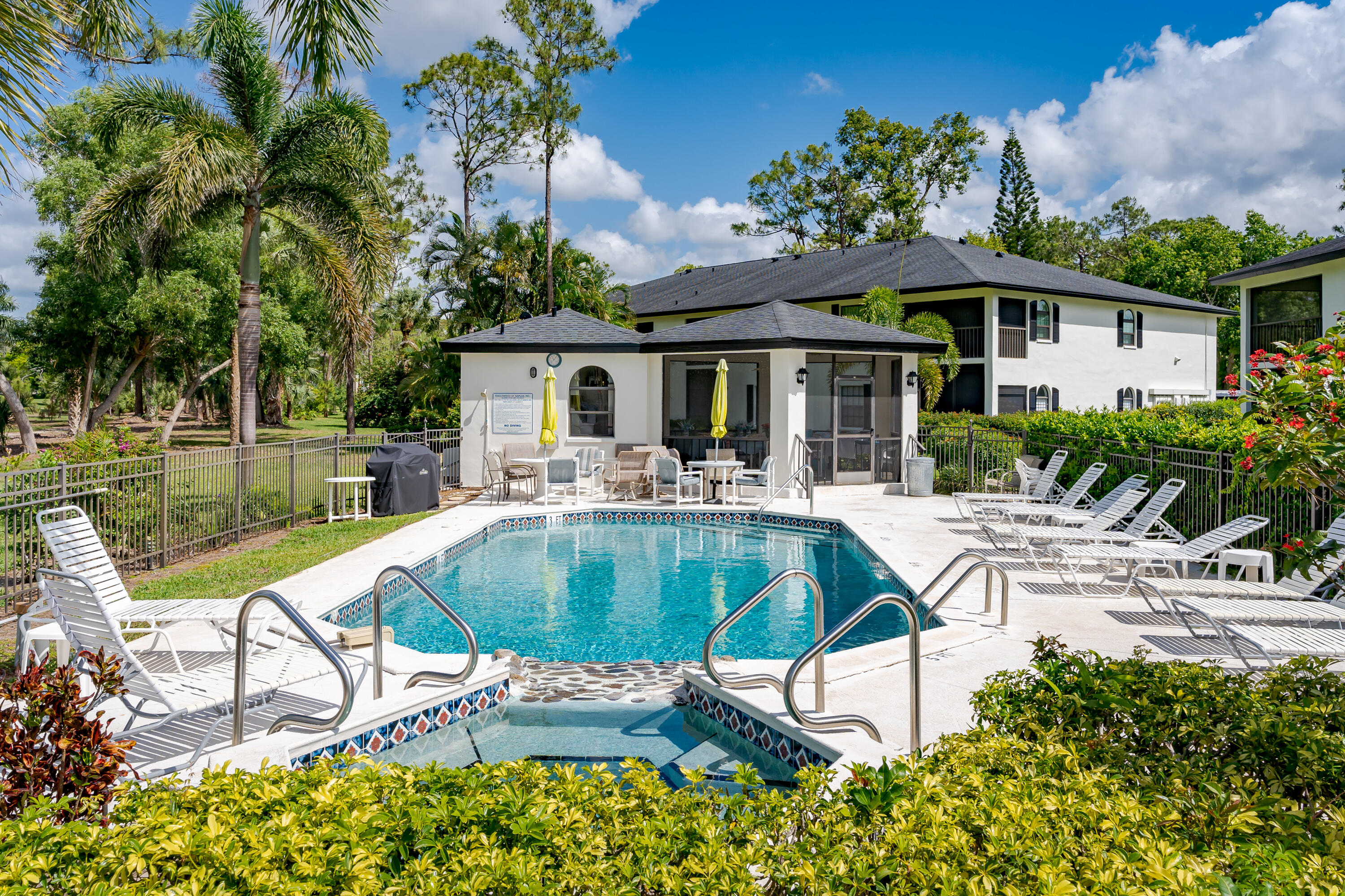 809 Augusta Boulevard, Unit 6 Naples, FL 34113 - Photo 20 of 24 a swimming pool with outdoor seating and yard