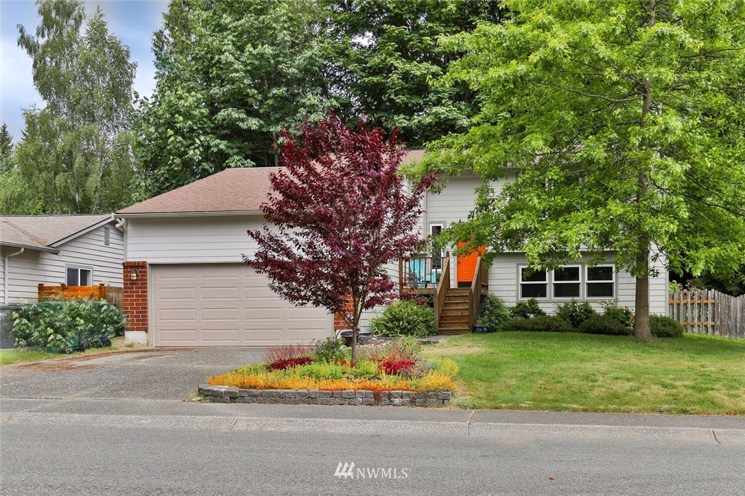 1933 169th Place Southeast Bothell, WA 98012 - Photo 1 of 34 a front view of a house with a garden and trees