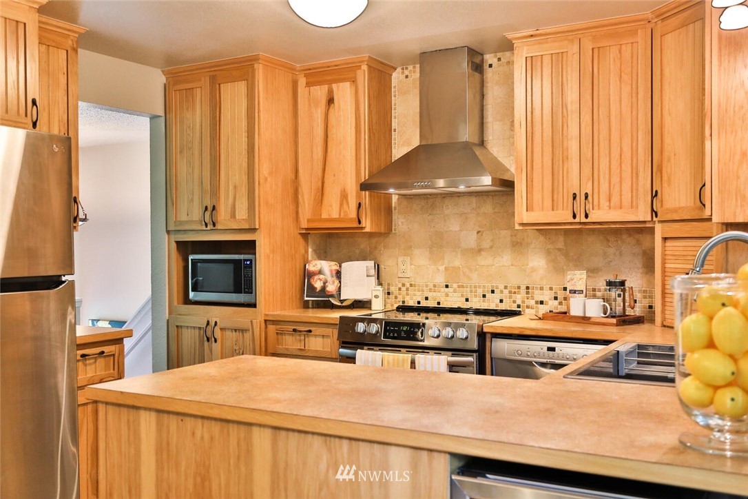 1933 169th Place Southeast Bothell, WA 98012 - Photo 12 of 34 a kitchen with stainless steel appliances a stove a sink a refrigerator and cabinets