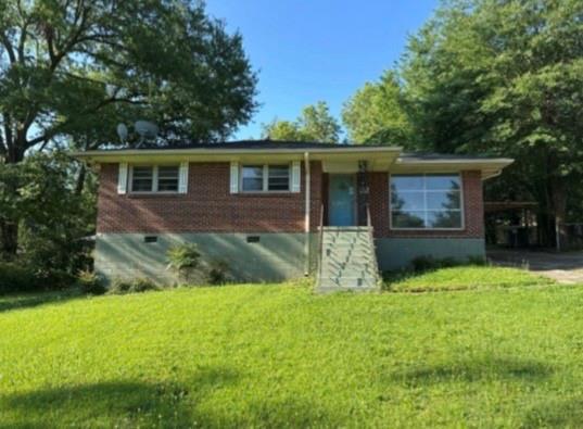 a view of a house with a yard and large trees