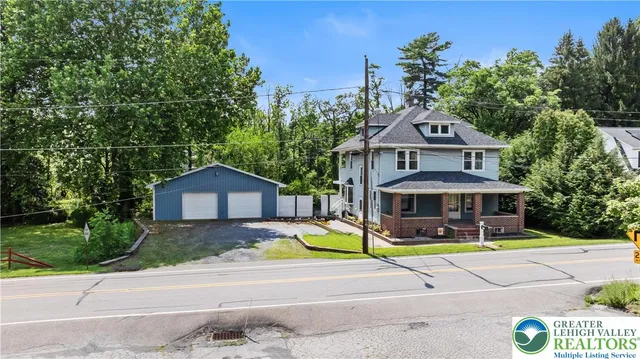 a view of a large house with a big yard and large trees