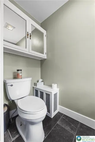 a bathroom with a toilet a sink and cabinets