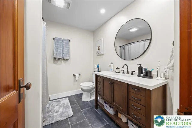 a bathroom with a toilet sink and mirror