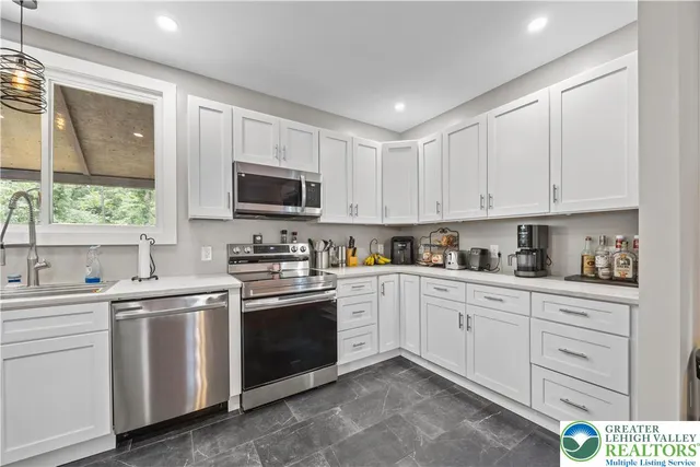 a kitchen with white cabinets sink and stainless steel appliances