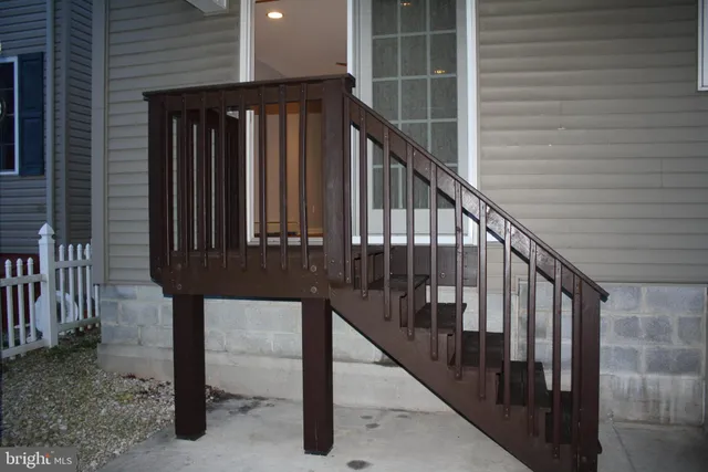 a view of staircase with railing and white walls