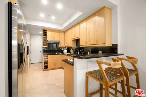 a kitchen with granite countertop white cabinets and stainless steel appliances