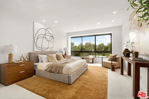a spacious bedroom with a bed and painting on the wall