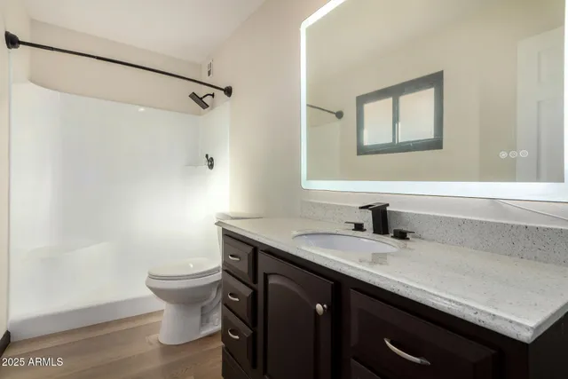 a bathroom with a granite countertop sink a toilet and a mirror