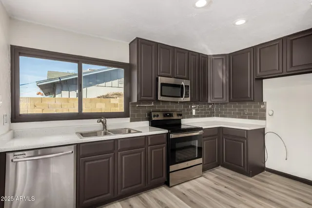 a kitchen with a sink stove top oven and cabinets