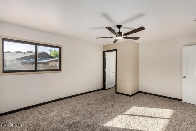 a view of a livingroom with a ceiling fan and window