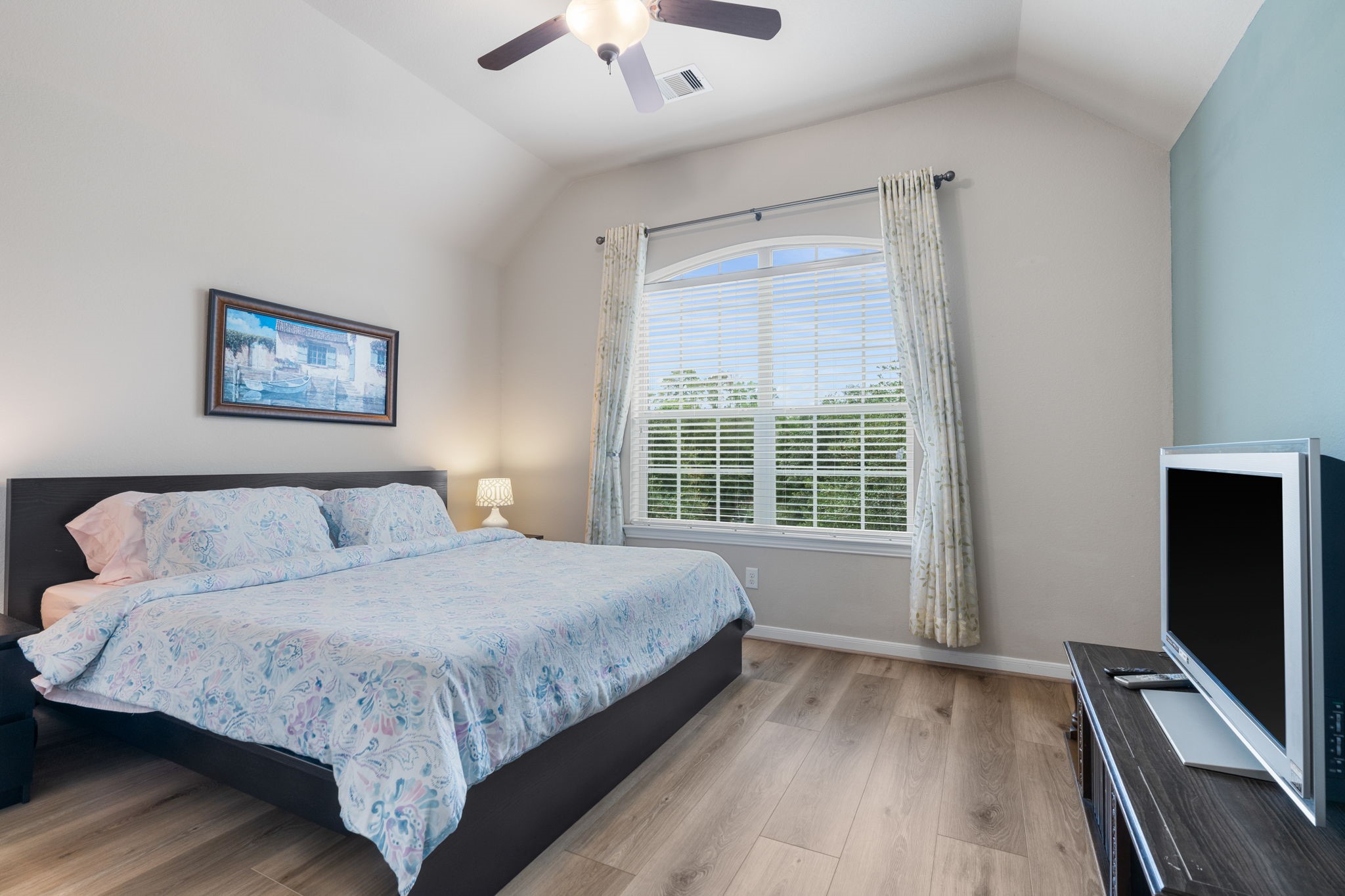 11 Pintuck Place Spring, TX 77389 - Photo 25 of 40 a bedroom with a large bed and a flat tv screen on a dresser
