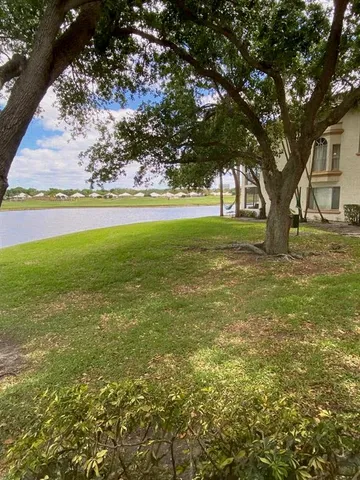 a view of yard with green space and trees