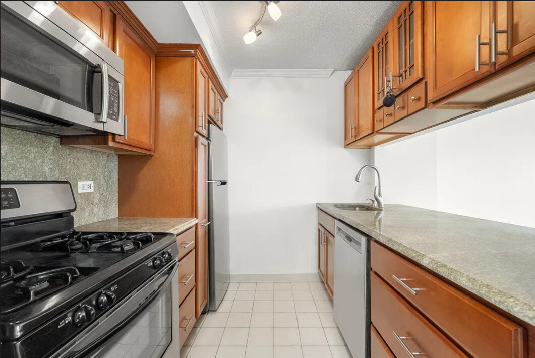 2 South End Avenue, Unit 8S Manhattan, NY 10280 - Photo 4 of 10 a kitchen with stainless steel appliances granite countertop a stove and a sink