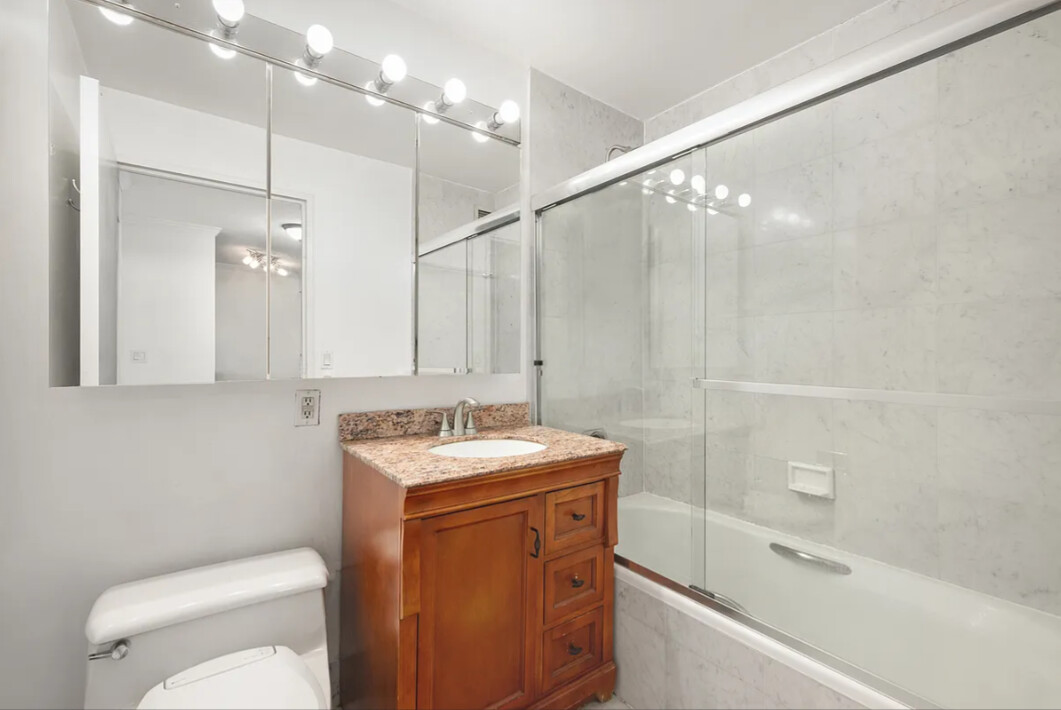 2 South End Avenue, Unit 8S Manhattan, NY 10280 - Photo 5 of 10 a bathroom with a sink a toilet a mirror and shower